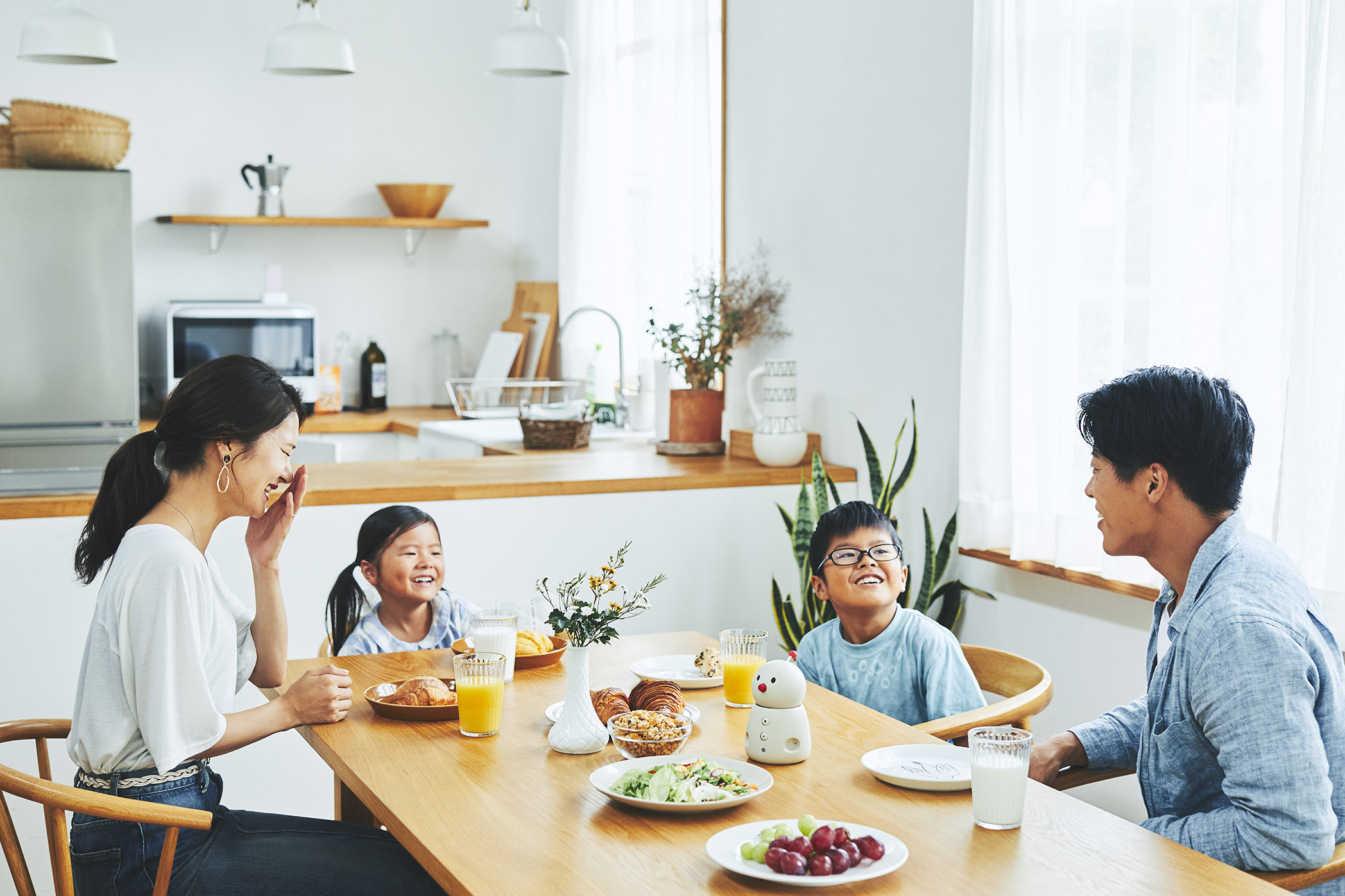 BOCCO emo communication robot by Yukai Engineering in a home setting, illustrating Japanese AgeTech for senior monitoring and family connectivity.