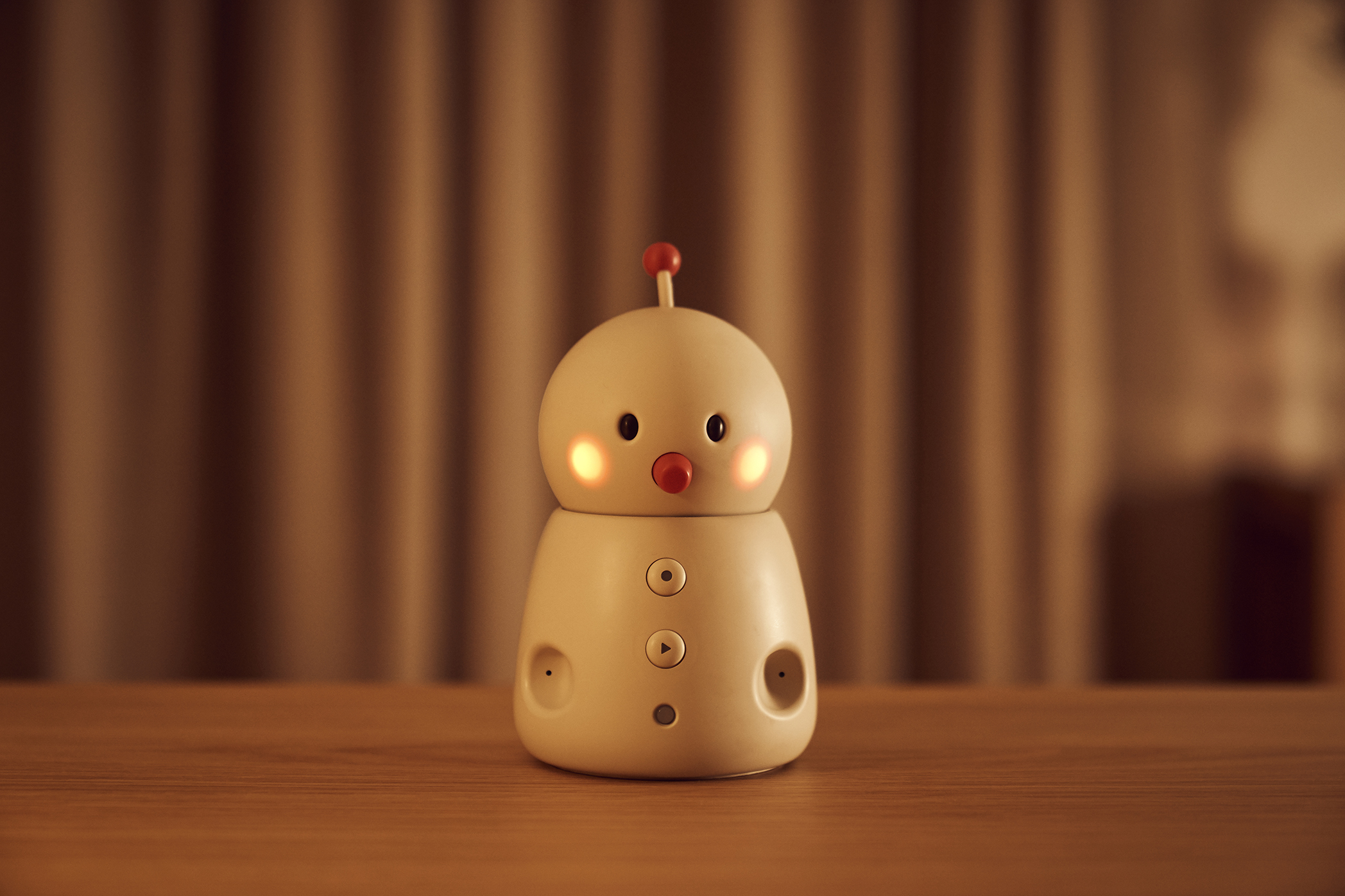 BOCCO emo communication robot by Yukai Engineering in a home setting, illustrating Japanese AgeTech for senior monitoring and family connectivity.