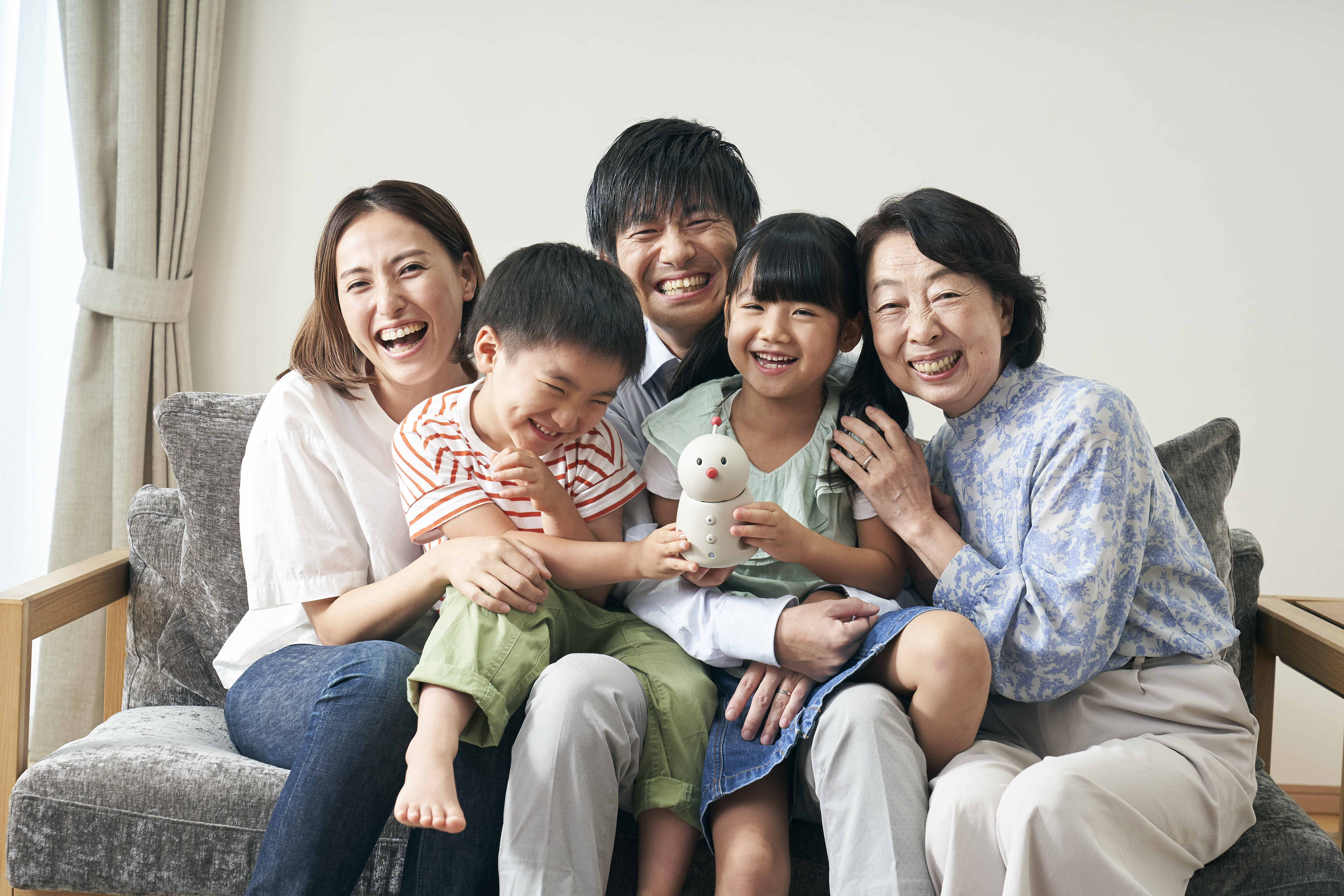 BOCCO emo communication robot by Yukai Engineering in a home setting, illustrating Japanese AgeTech for senior monitoring and family connectivity.